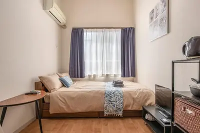 a small bedroom with a bed and a window at Plaza de La Brea in Tokyo