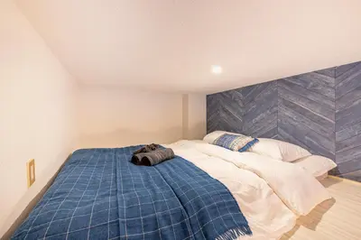 a bedroom with a bed with a blue blanket at Plaza de La Brea in Tokyo