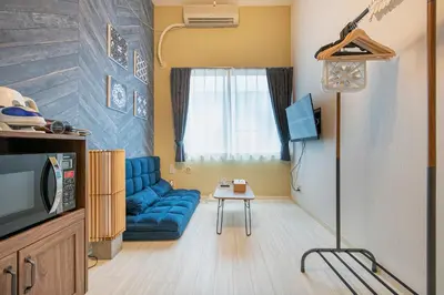 a living room with a blue couch and a tv at Plaza de La Brea in Tokyo