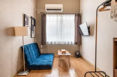 a living room with a blue couch and a table at Plaza de La Brea in Tokyo