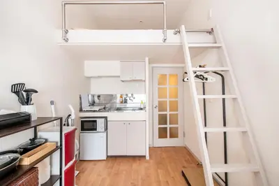 a small kitchen with a loft bed in a tiny apartment at Plaza de La Brea in Tokyo