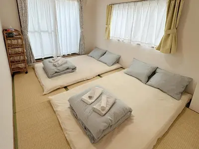 two beds in a room with two windows at W-inns okazaki in Tokyo