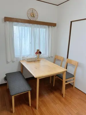 a wooden table and chairs in a room with a window at W-inns okazaki in Tokyo