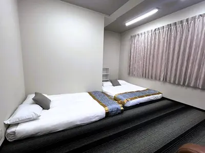 two beds in a bedroom with a window at \u6d45\u8349\u30a2\u30d1\u30fc\u30c8\u30e1\u30f3\u30c8 in Tokyo