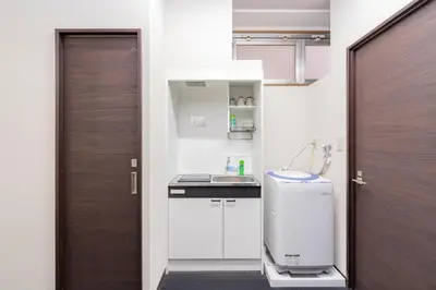 a small kitchen with a sink next to a door at \u6d45\u8349\u30a2\u30d1\u30fc\u30c8\u30e1\u30f3\u30c8 in Tokyo
