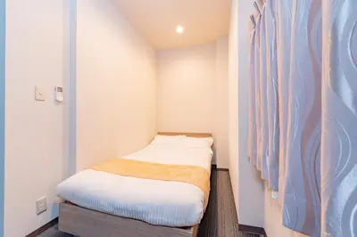 a small room with a small bed in it at \u6d45\u8349\u30a2\u30d1\u30fc\u30c8\u30e1\u30f3\u30c8 in Tokyo