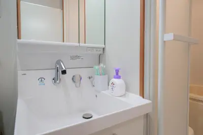 a white bathroom sink with a mirror and toothbrushes at Itabashi Minamicho ten, Diamond Yu - Vacation STAY 61425v in Tokyo