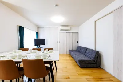 a dining room with a table and a couch at Bliss KAMEARI in Tokyo