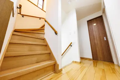 a staircase in a house with a wooden door at Bliss KAMEARI in Tokyo