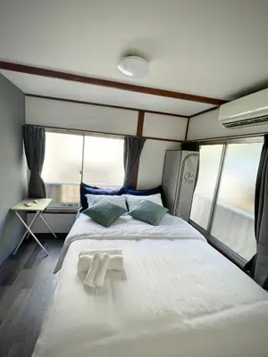 a large white bed in a room with windows at RED House｜12 minutes from the station｜Quiet area｜Direct access to Shinjuku & Akihabara in Tokyo