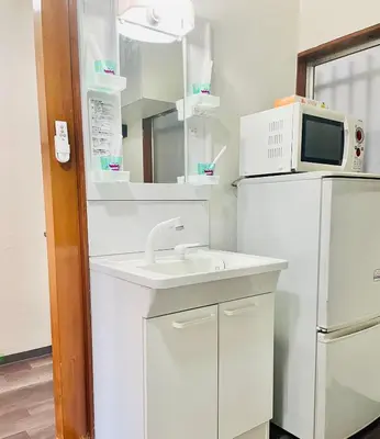 a kitchen with a sink and a microwave and a refrigerator at RED House｜12 minutes from the station｜Quiet area｜Direct access to Shinjuku & Akihabara in Tokyo