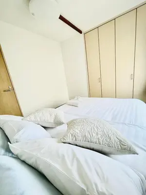 two beds with white sheets and pillows in a bedroom at RED House｜12 minutes from the station｜Quiet area｜Direct access to Shinjuku & Akihabara in Tokyo