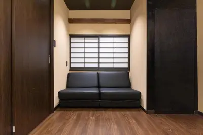 a black leather couch in a room with a window at Asakura Ninja House Tokyostoryhotel, Tokyo Skytree in Tokyo