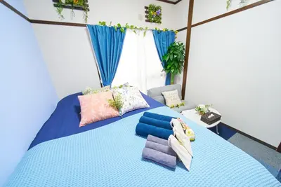 a bedroom with a blue bed with pillows on it at Belmont 202 3min to Station Easy Access Ueno Asakusa Skytree Sleeps 5 in Tokyo