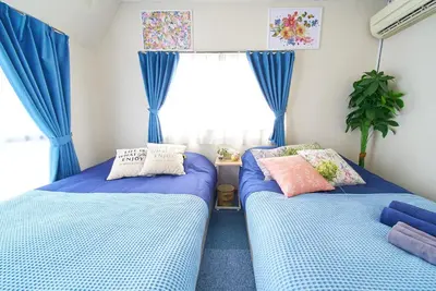 two beds in a room with blue curtains at Belmont 301 3min to Station Easy Access Ueno Asakusa Skytree Sleeps 5 in Tokyo