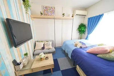 a room with two beds and a flat screen tv at Belmont 302 3min to Station Easy Access Ueno Asakusa Skytree Sleeps 5 in Tokyo