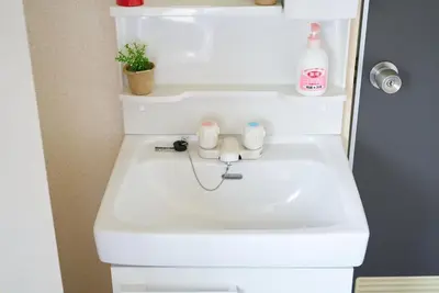 a white sink in a bathroom with a bottle of soap at Belmont 302 3min to Station Easy Access Ueno Asakusa Skytree Sleeps 5 in Tokyo