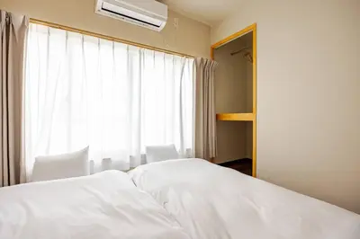 a bedroom with a white bed and a window at \u6771\u6d45\u83492\u4e01\u76eeb202 in Tokyo