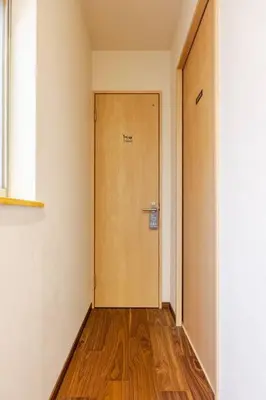 a hallway with a wooden door in a room at \u6771\u6d45\u83492\u4e01\u76eeb202 in Tokyo