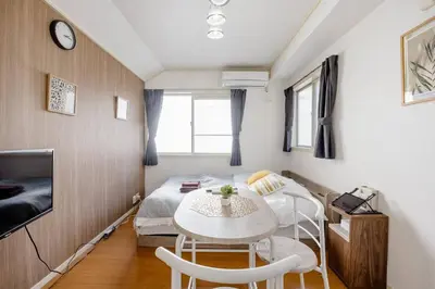 a small room with a bed and a table and chairs at Maison Shin Nakano 203 MS23 in Tokyo