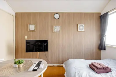 a room with a bed and a tv on a wall at Maison Shin Nakano 203 MS23 in Tokyo