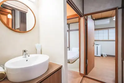 a bathroom with a white sink and a mirror at Asakusa 5 Chome KazeNoItsu Home in Tokyo