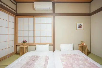 a bedroom with two beds and a window at Asakusa 5 Chome KazeNoItsu Home in Tokyo
