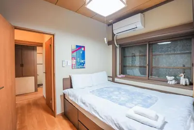 a bedroom with a large bed and a window at Asakusa 5 Chome KazeNoItsu Home in Tokyo