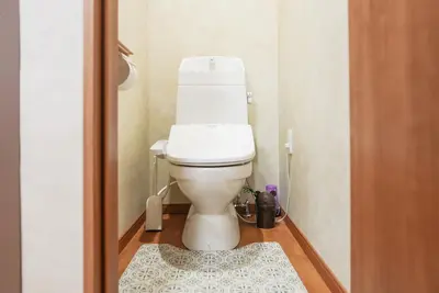 a bathroom with a toilet with a rug on the floor at Asakusa 5 Chome KazeNoItsu Home in Tokyo
