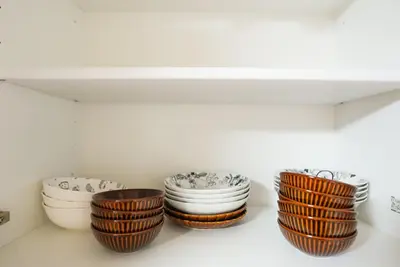 a group of bowls sitting on a shelf at Asakusa 5 Chome KazeNoItsu Home in Tokyo