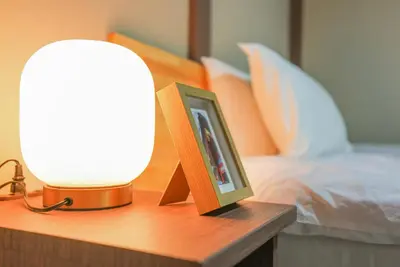 a lamp and a picture on a table next to a bed at Asakusa 5 Chome KazeNoItsu Home in Tokyo