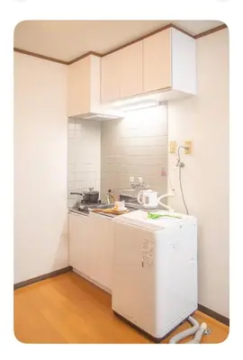 a small kitchen with white cabinets and a refrigerator at Shinjuku 2 stops, 3 people,station walk for 4 mins in Tokyo