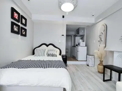 a white bedroom with a large bed and a kitchen at Shibuya Center-\u6e0b\u8c37\u7ad9\u5f92\u6b654min-\u65b0\u5bbf\u516d\u672c\u6728\u4e0a\u91ce\u76f4\u8fbe-New Open Max4P in Tokyo