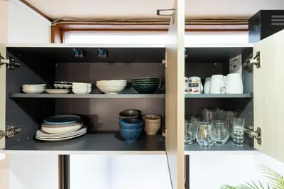 a cupboard filled with plates and bowls and dishes at \u4e00\u68df\u8cb8\u5207 \u99d2\u8fbc\u30d5\u30eb\u30ea\u30ce\u30d9\u30fc\u30b7\u30e7\u30f3\u53e4\u6c11\u5bb6 Switch\u4ed8\u304d \u6c60\u888b\u65b0\u5bbf\u6e0b\u8c37\u79cb\u8449\u539f in Tokyo
