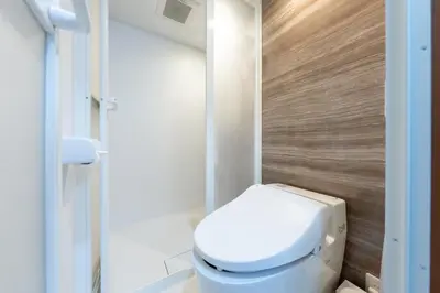 a bathroom with a white toilet and a wooden wall at \u4e00\u68df\u8cb8\u5207 \u99d2\u8fbc\u30d5\u30eb\u30ea\u30ce\u30d9\u30fc\u30b7\u30e7\u30f3\u53e4\u6c11\u5bb6 Switch\u4ed8\u304d \u6c60\u888b\u65b0\u5bbf\u6e0b\u8c37\u79cb\u8449\u539f in Tokyo