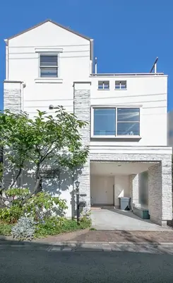 a white brick house with a garage at NEW! Pufuka Oshiage \u3077\u3075\u304b\u62bc\u4e0a in Tokyo
