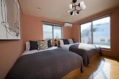 a bedroom with two beds and a window at NEW! Pufuka Oshiage \u3077\u3075\u304b\u62bc\u4e0a in Tokyo