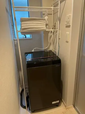 a black refrigerator in a room with some towels at Shinjuku \u65b0\u5bbf\u533a\u5730\u4e0b\u9244\u99c5\u307e\u3067\u5f92\u6b694\u5206 in Tokyo