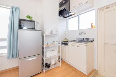 a kitchen with white cabinets and a refrigerator at mori house\u897f\u304c\u4e18 in Tokyo