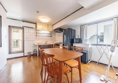 a kitchen with a wooden table and some chairs at Benir Maison Izumi in Tokyo