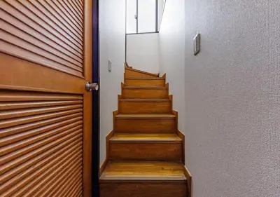 a staircase with wooden steps next to a door at Benir Maison Izumi in Tokyo