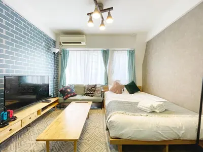 a room with two beds and a flat screen tv at LVB Shibuyadogenzaka in Tokyo