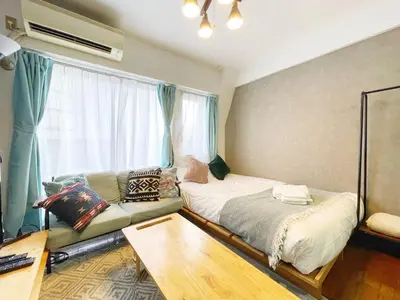 a room with two beds and a couch and a window at LVB Shibuyadogenzaka in Tokyo