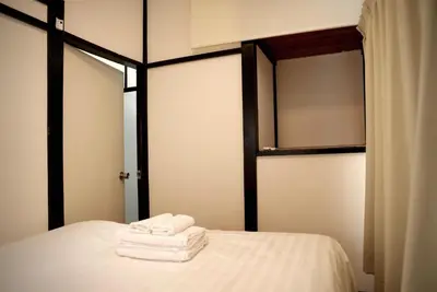 two towels sitting on top of a bed with a window at Green & Orange House - Economic APT in Tokyo Tranquil Block, with Direct Access to Ginza & Akihabara in Tokyo