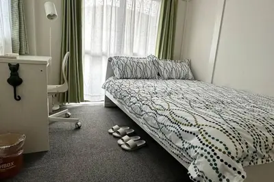 a bedroom with a bed with shoes on the floor at Warmhome-hirai2F in Tokyo