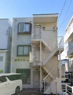 a white car parked in front of a brick building at Warmhome-hirai2F in Tokyo