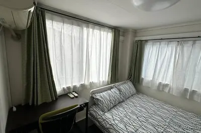 a bedroom with a bed and a desk with a window at Warmhome-hirai2F in Tokyo
