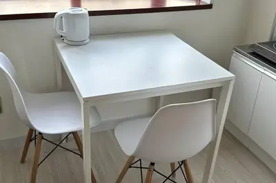 a white table and two chairs in a kitchen at Warmhome-hirai3F in Tokyo