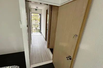 a hallway with a door leading to a hallway with a door at Warmhome-hirai3F in Tokyo