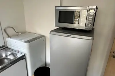 a microwave sitting on top of a refrigerator at Warmhome-hirai3F in Tokyo
